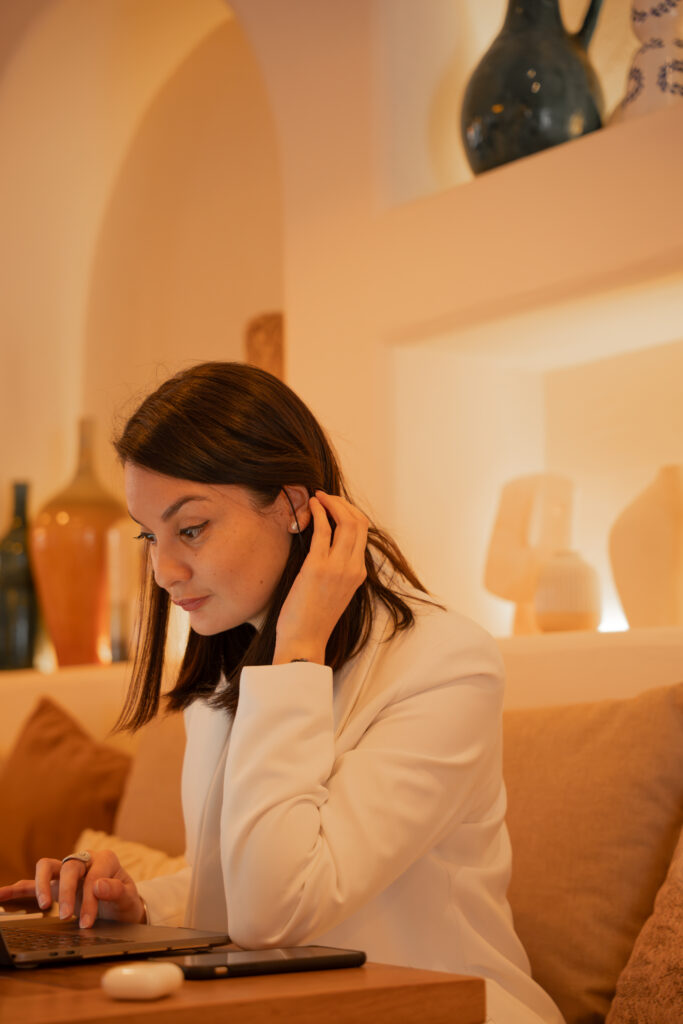 Portrait professionnel de Mélanie Carcenac, consultante spécialisée en neuroatypie, de profil souriante en chemise blanche