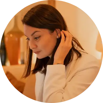 Portrait professionnel de M&eacute;lanie Carcenac, consultante sp&eacute;cialis&eacute;e en neuroatypie, de profil souriante en chemise blanche