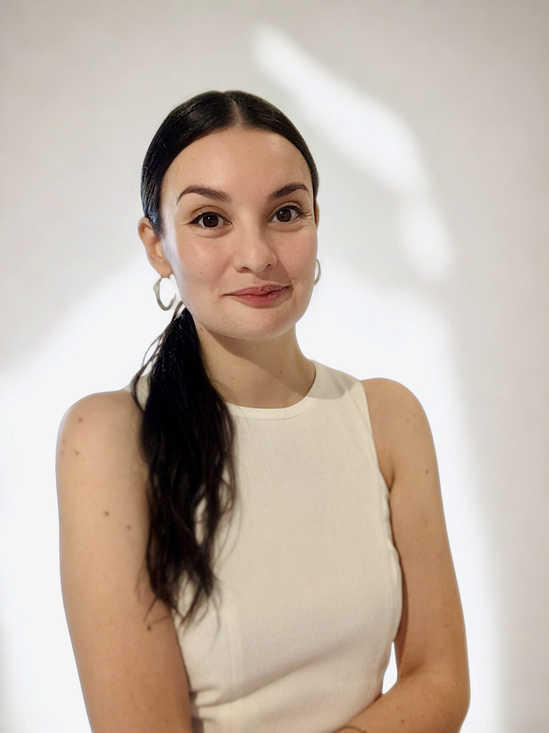 Portrait professionnel de M&eacute;lanie Carcenac, consultante sp&eacute;cialis&eacute;e en neuroatypie, de profil souriante en robe blanche